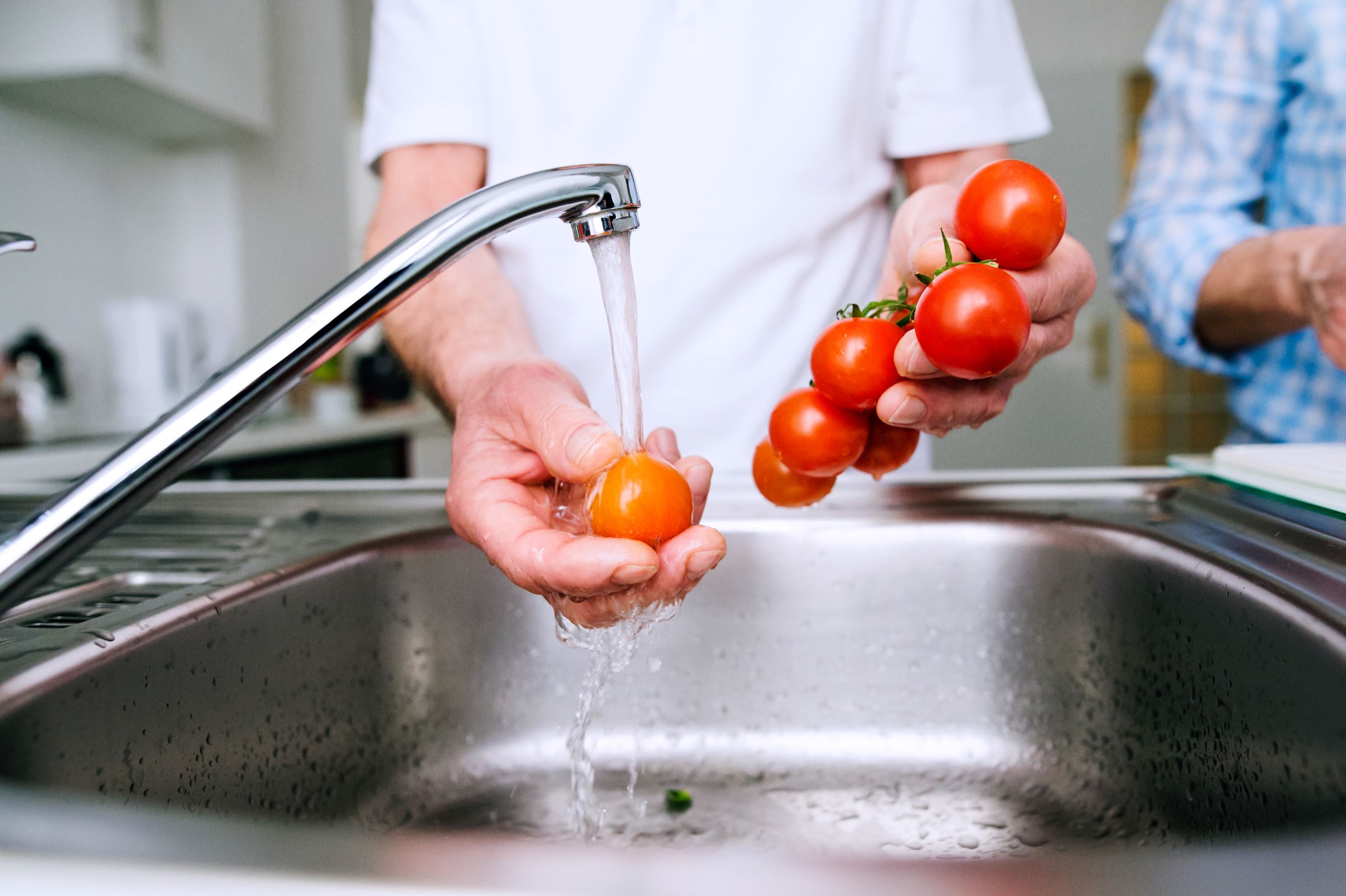 washing hands and veggies in sink